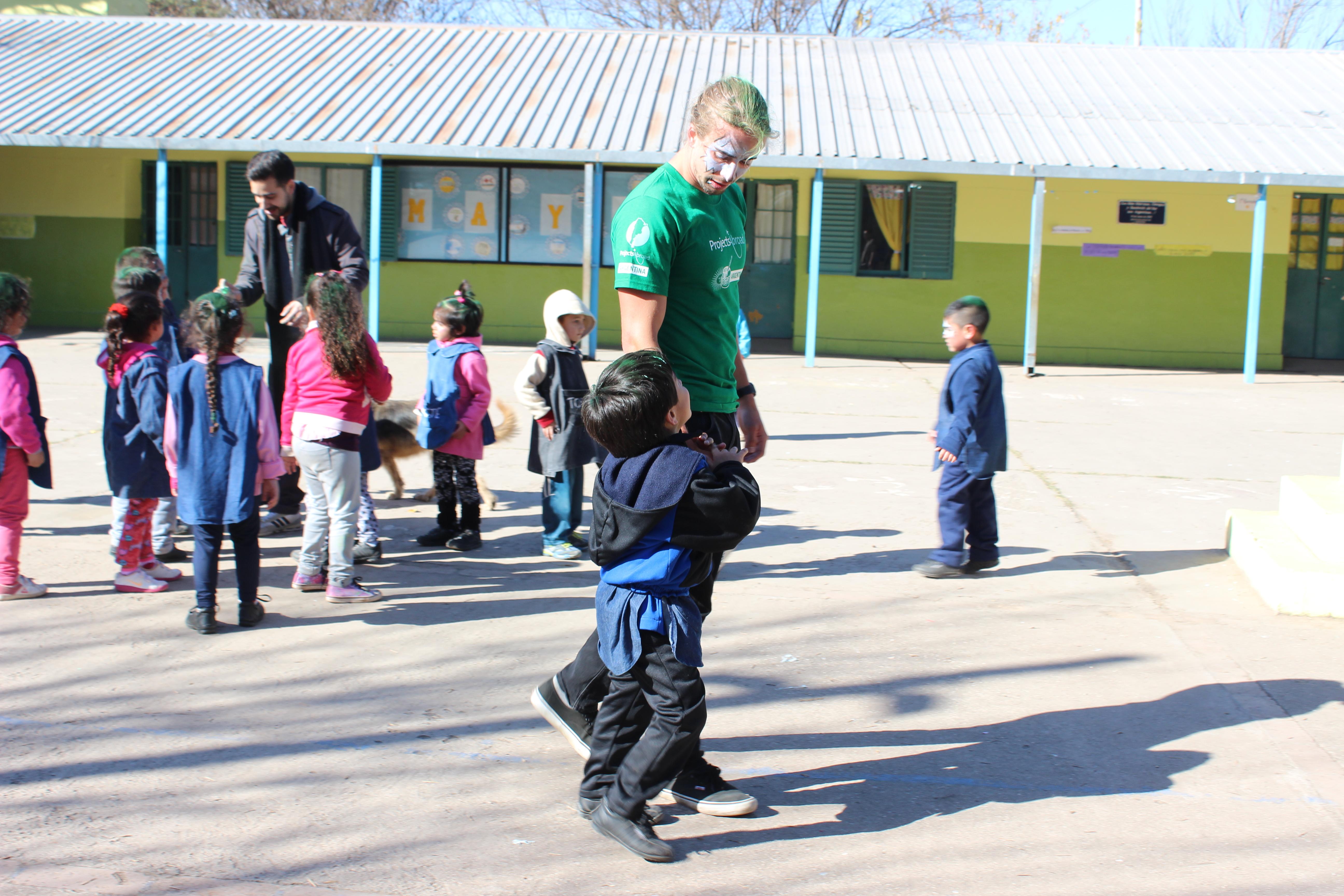 A Projects Abroad volunteer speaking with children in Argentina on our programme for high school students A teenager spends time with children as part of his volunteer work in Argentina